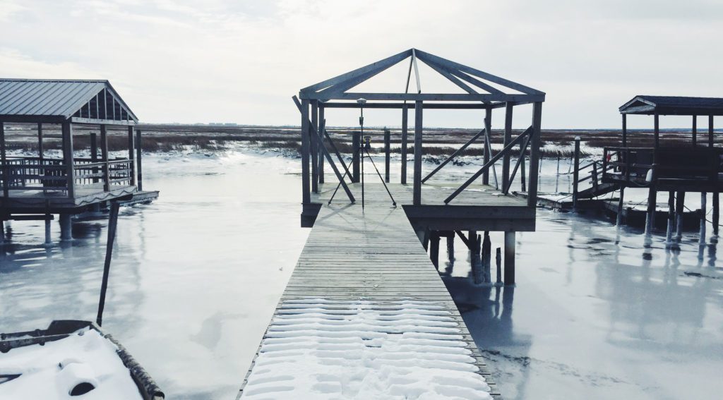 Frozen pier with wooden structures on lake.