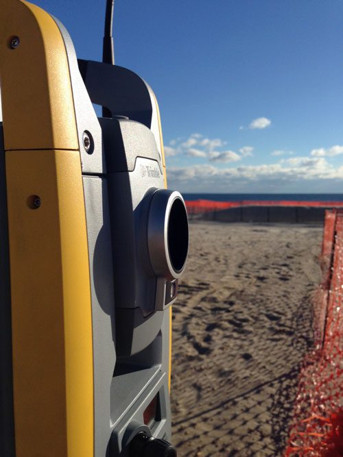 Total station near ocean under blue sky